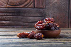 Sweet dates clay plate stone tile wooden background 300x200